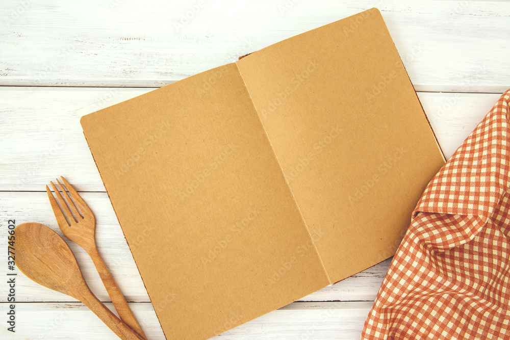 brown recipe cooking book on a white wooden bord