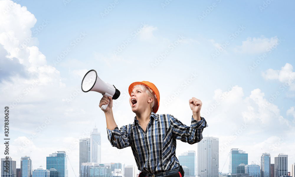 Expressive woman in helmet shouting into megaphone