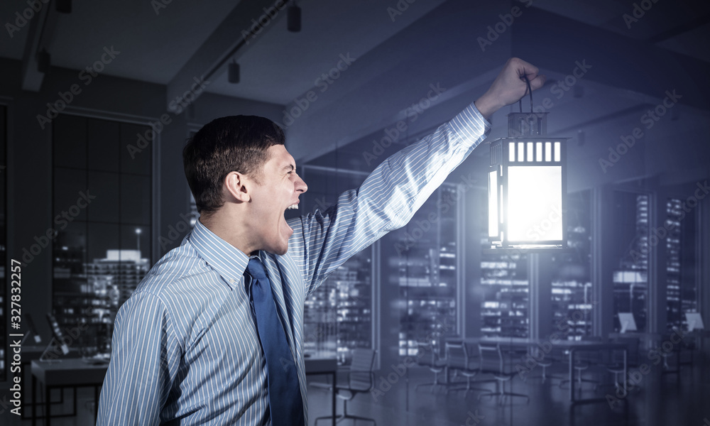 Screaming businessman holding glowing lantern