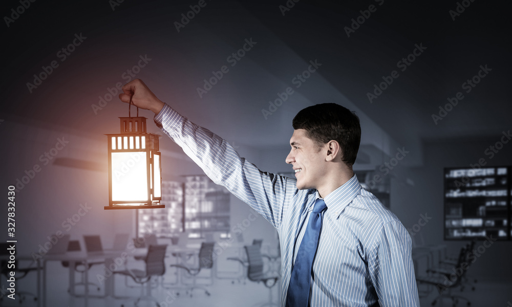 Happy businessman holding glowing lantern