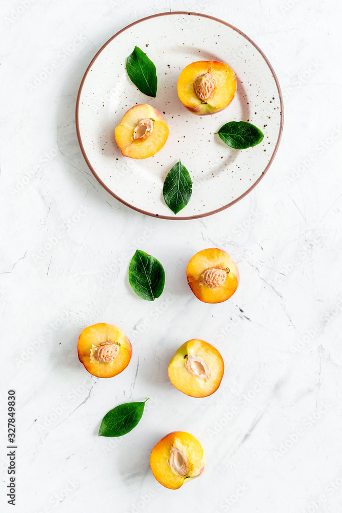 Peaches pattern with plate and leaves on white table top-down