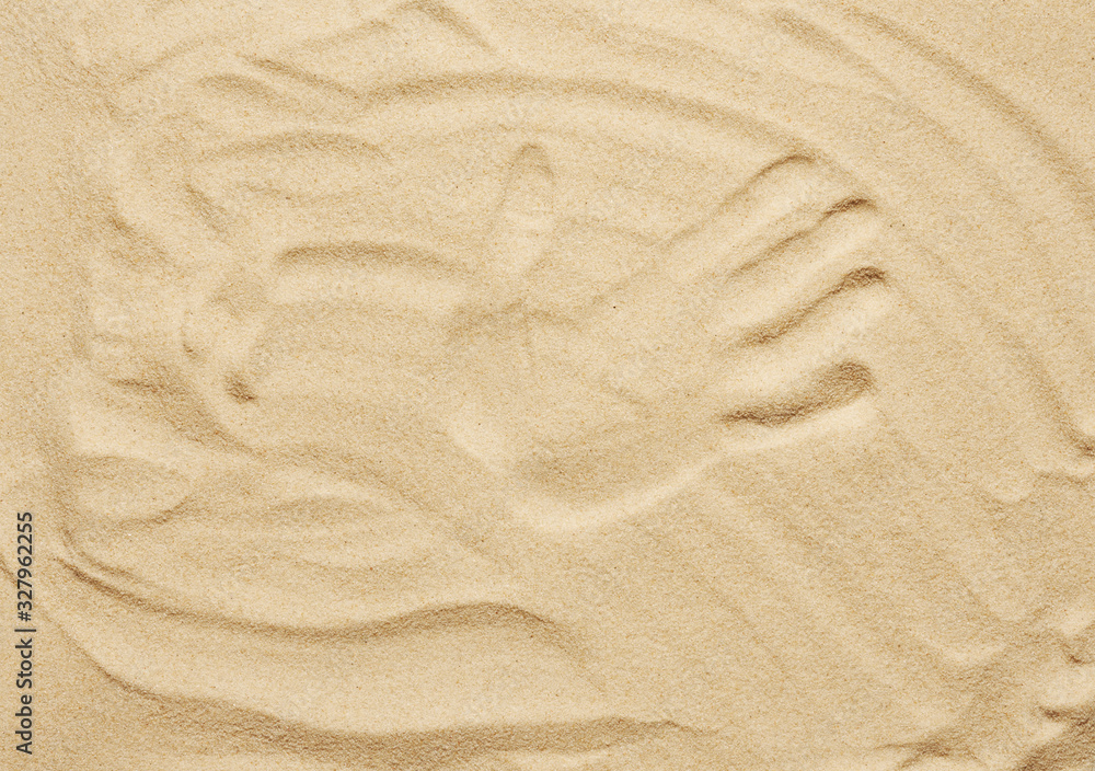 Tropical sand background. Sandy beach texture with handprint. Top view