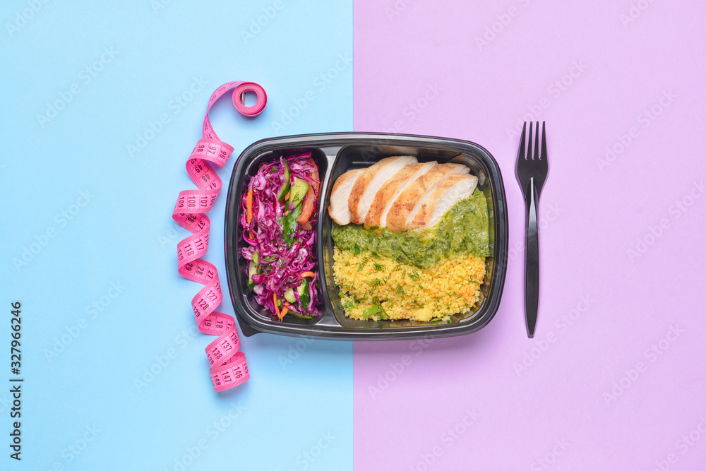 Container with healthy food and measuring tape on color background