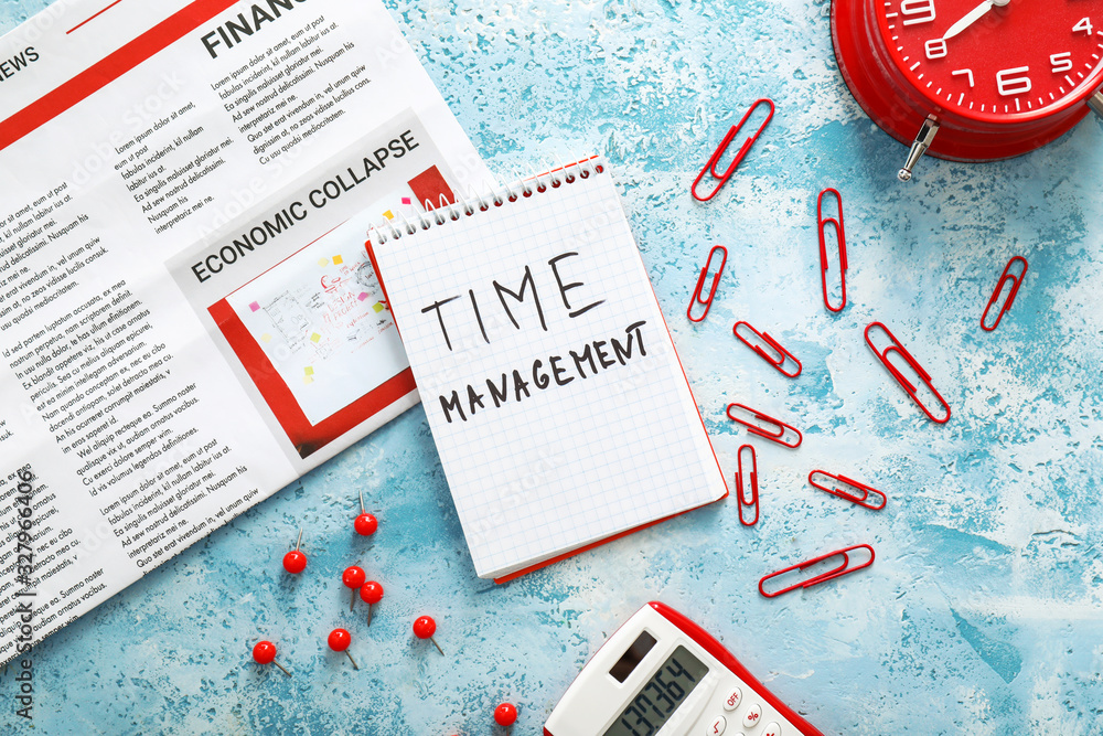 Notebook with text TIME MANAGEMENT, newspaper and stationery on table