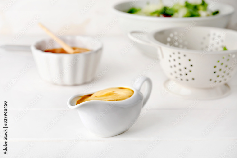 Gravy boat of tasty honey mustard sauce on white wooden table