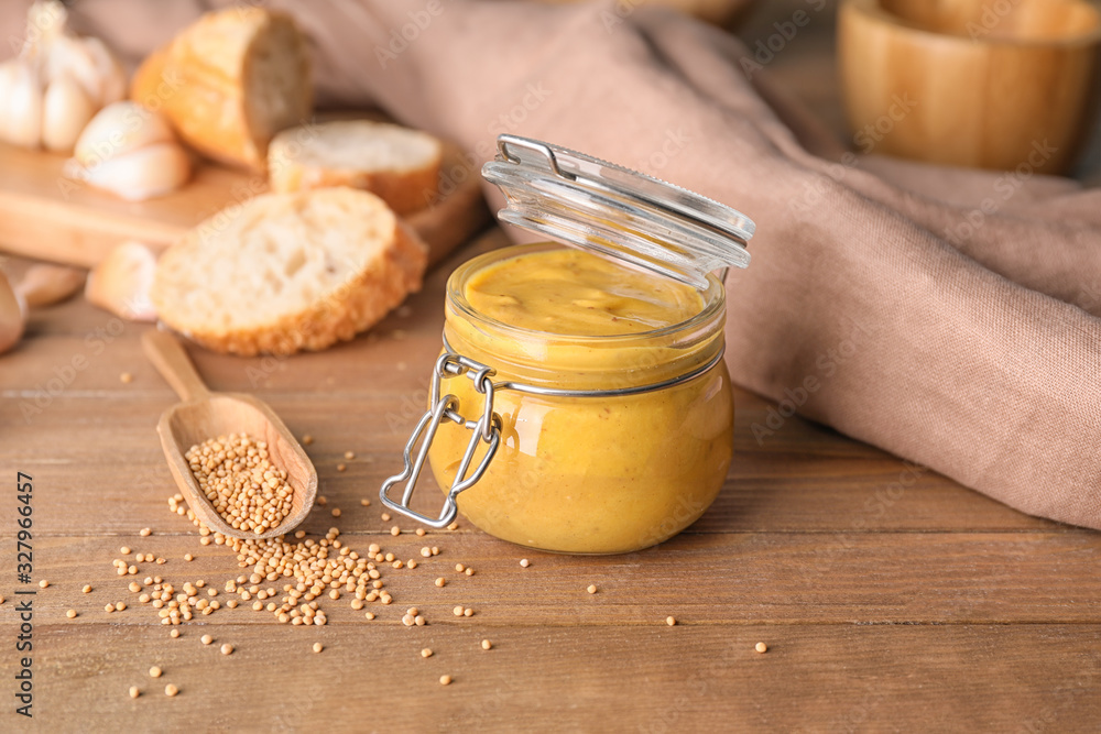 Jar of tasty honey mustard sauce on wooden table