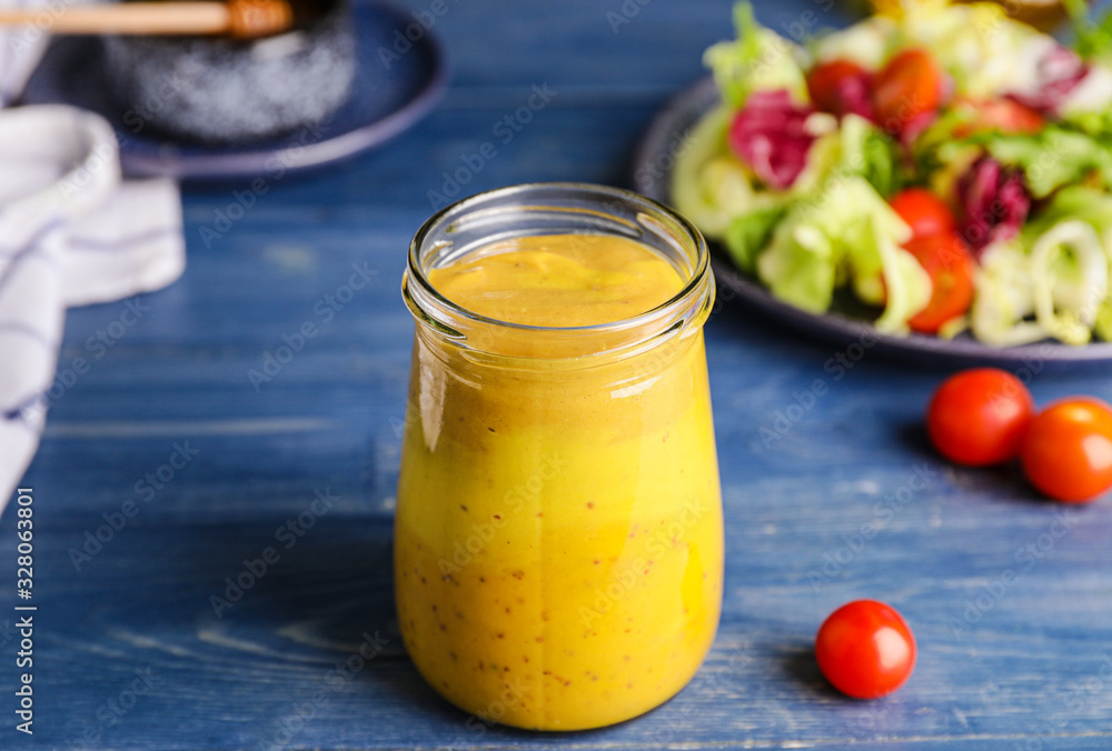 Jar of tasty honey mustard sauce on wooden table