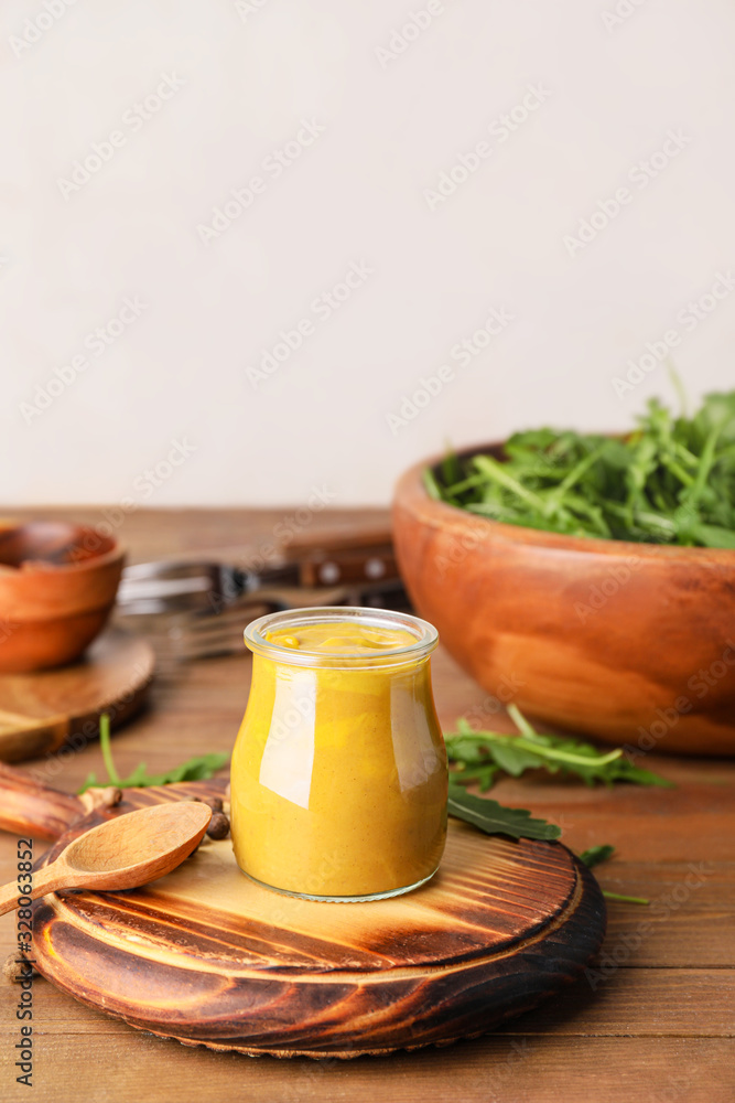 Jar of tasty honey mustard sauce on wooden table