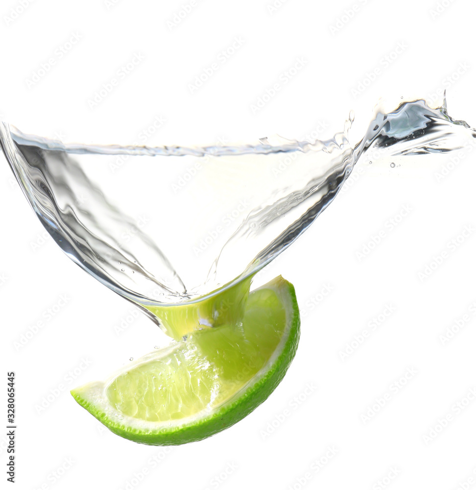 Fresh lime piece falling into water against white background