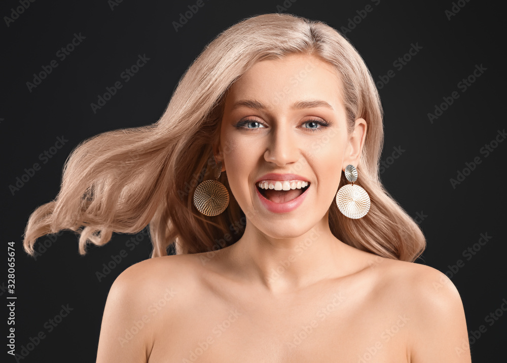 Young blonde with beautiful hair on dark background