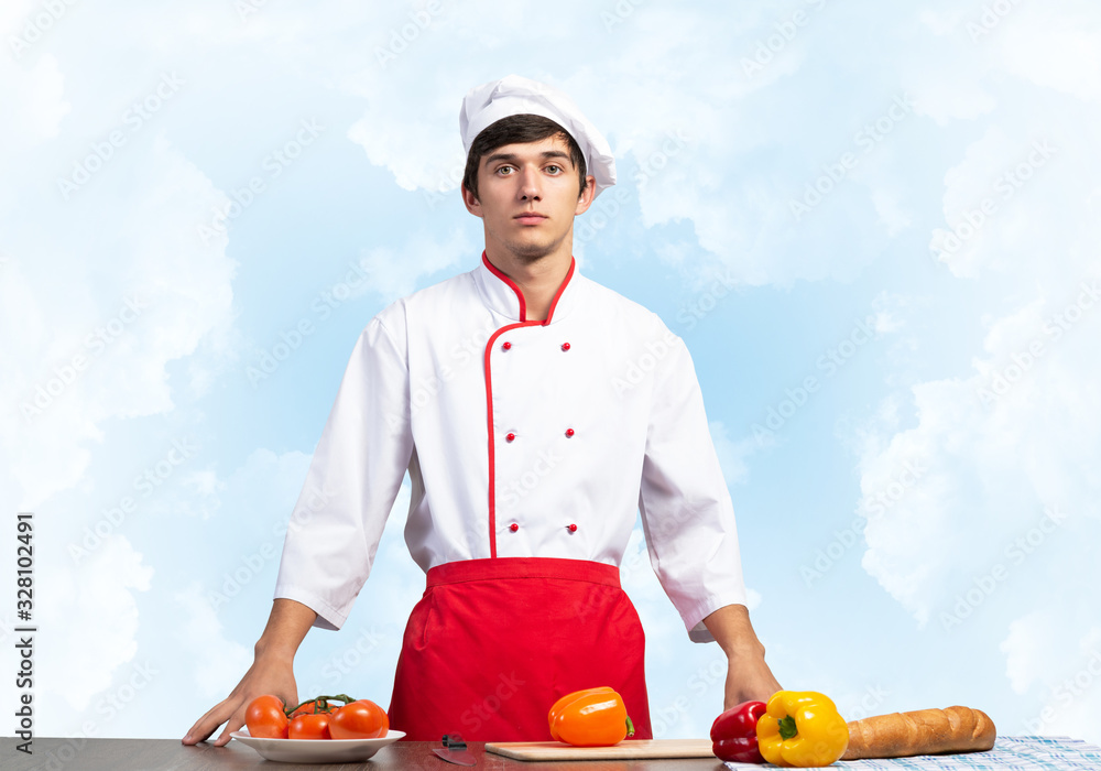 Young male chef standing near cooking table