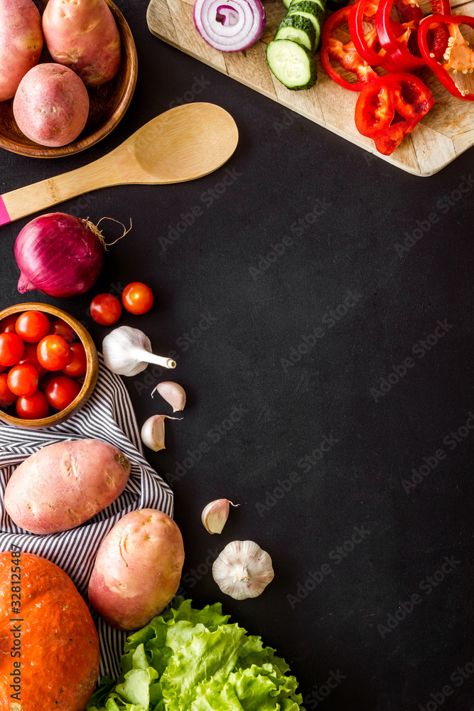 Autumn harvest. Vegetables - potato,cucumber, corn, greenery - frame on black background top-down co