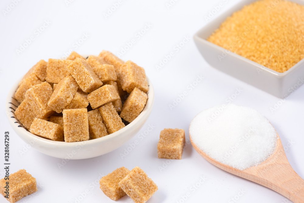 Brown sugar in a round glass cup and wooden spoon on a white background, healthy sugar is used for c