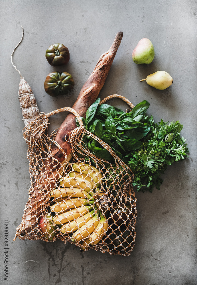 Flat-lay of healthy grocery shopping eco-friendly bag with fresh vegetables, fruit, greens, bread an