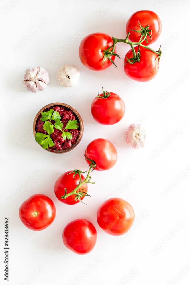 Tomato frame with suase and garlic on white background top-down