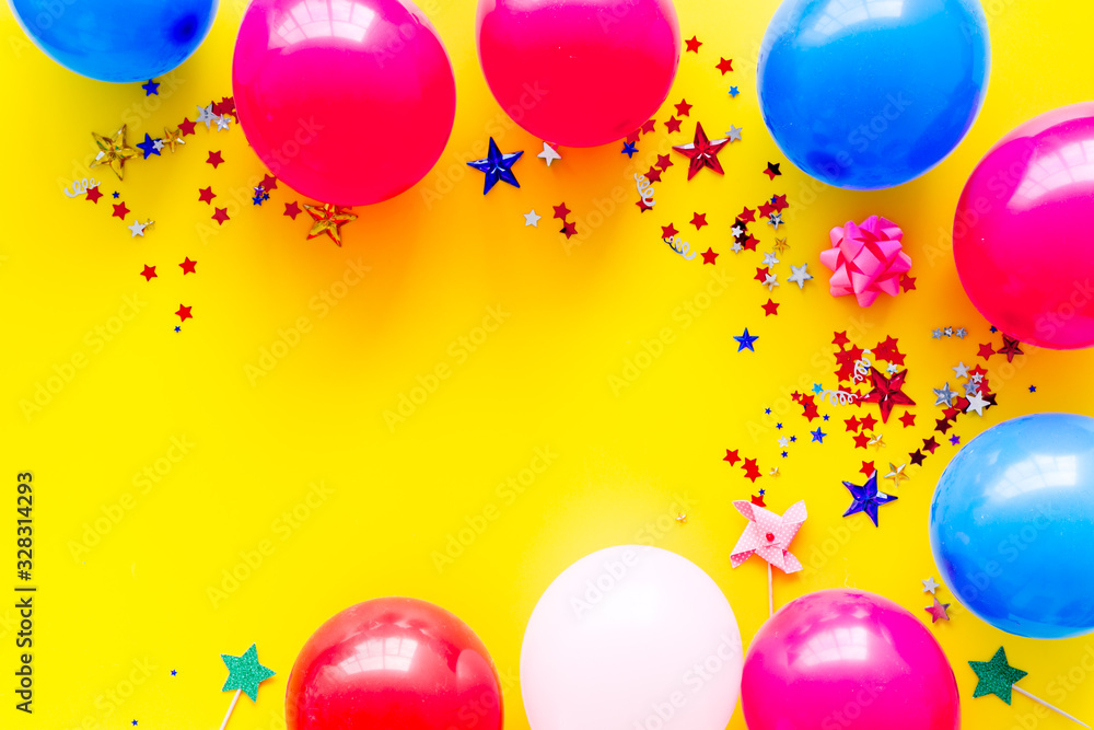 Party concept. Colorful balloons and confetti on yellow background top-down frame copy space