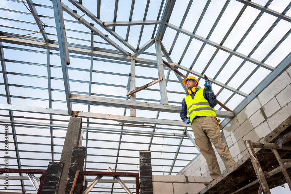 The construction engineer is constructing the steel roof structure of the house. House construction 