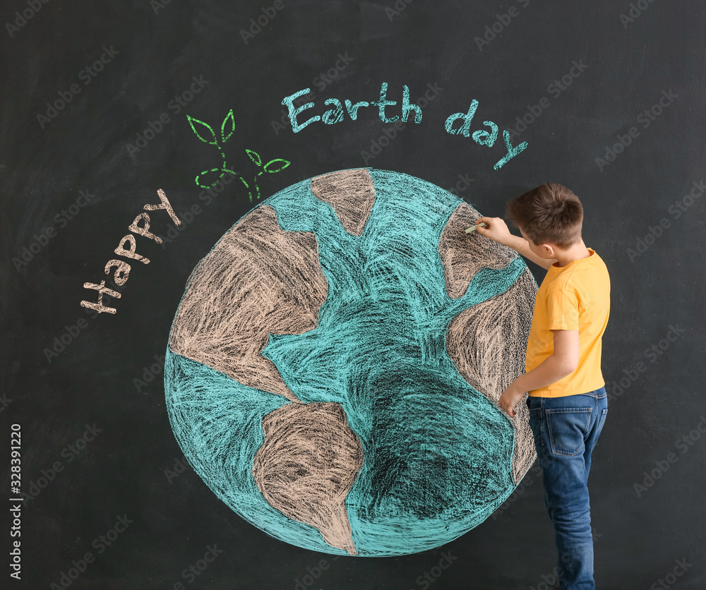 Little boy drawing planet on dark background. Earth Day celebration