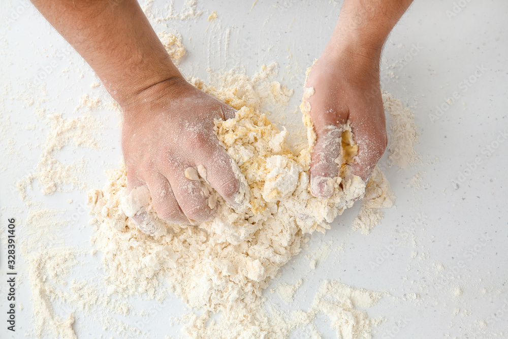 Man kneading dough on table, closeup