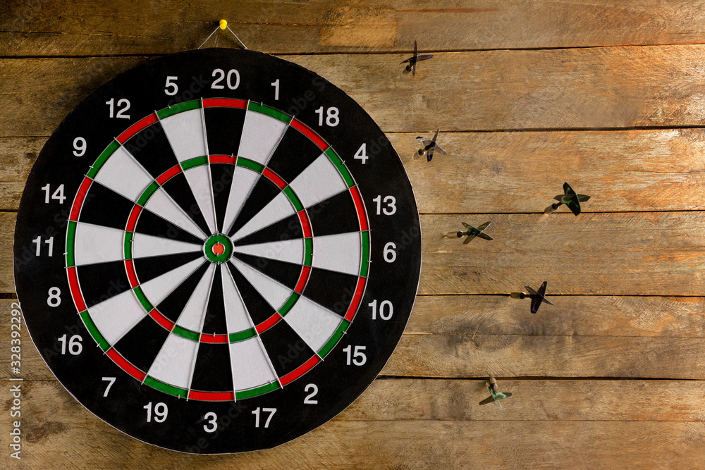 Darts with dartboard on wooden background