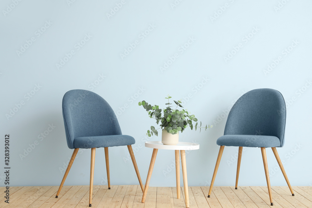 Modern chairs and table near color wall