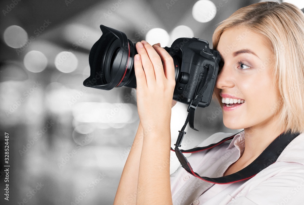 Beautiful female photographer with a camera on background