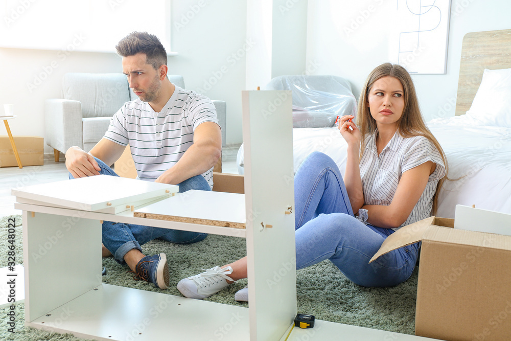 Quarreled couple during assembling furniture at home