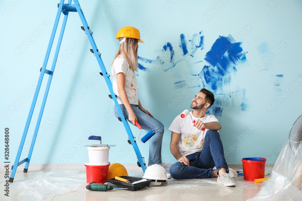 Happy young couple doing repair in their new house