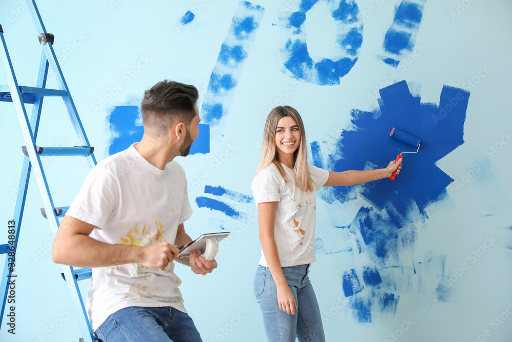 Happy young couple doing repair in their new house