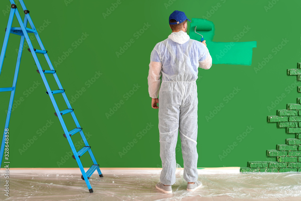 Male painter doing repair in room