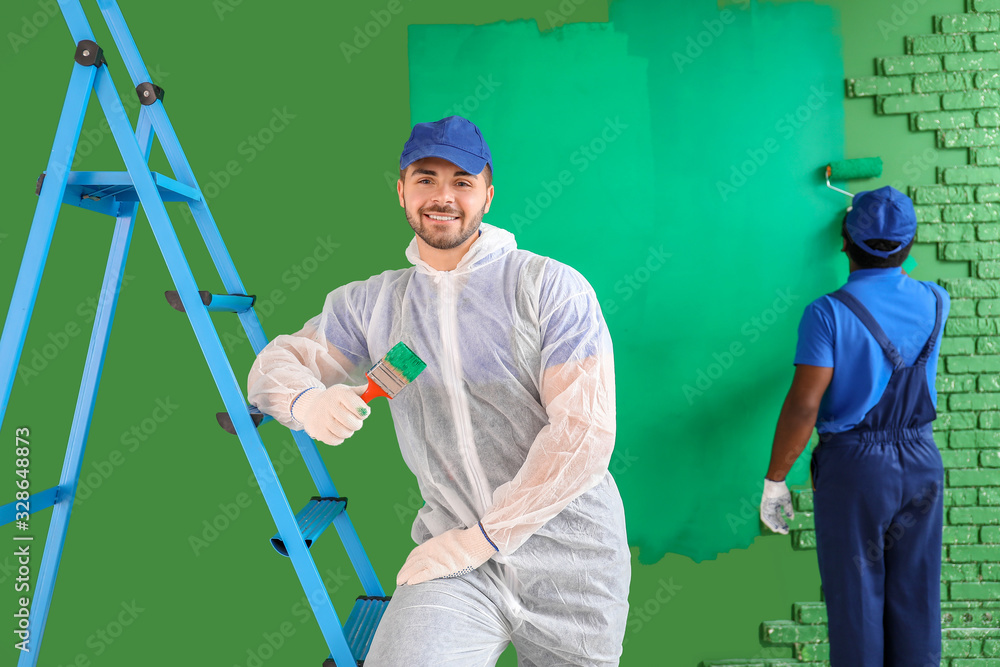 Male painters doing repair in room