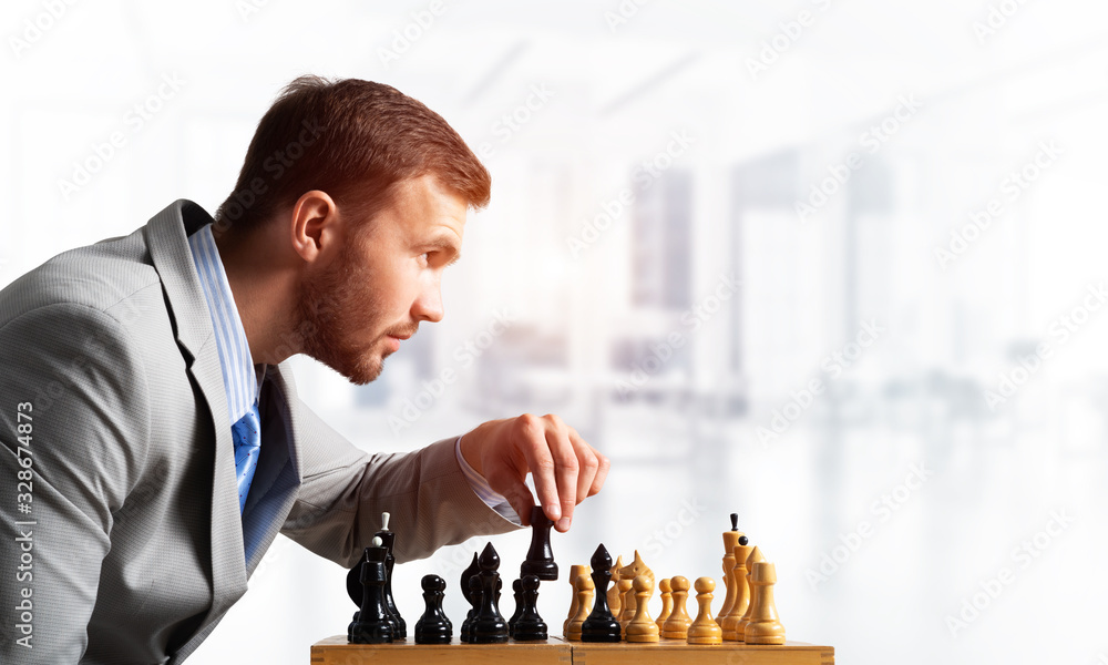 Concentrated businessman playing chess game