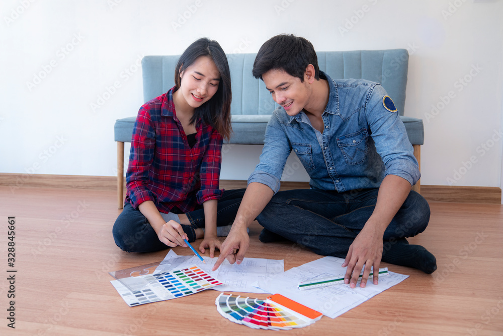 Young happy smiling couple choosing colors for painting their home, this image can use for family, h