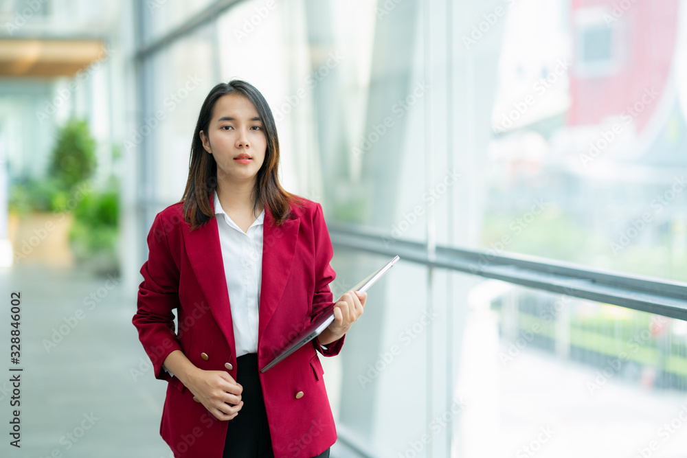 年轻微笑的女人拿着笔记本电脑俯瞰市中心