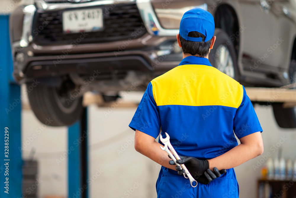 Asian worker in uniform working in car engine