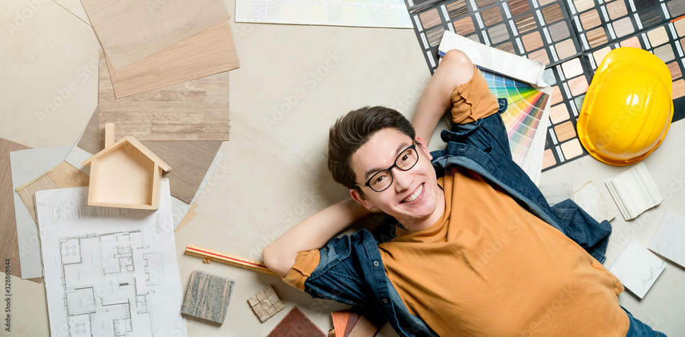 smart happiness asian man house owner laydown on floor with house material sample frame around home 