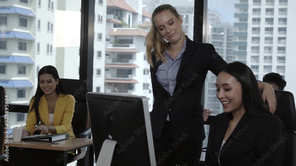 Young leader gives advice to young woman worker in modern office. Leadership and training concept.