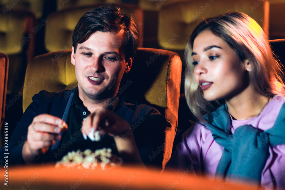 Caucasian lover enjoying to watch movie and eating popcorn together in the cinema