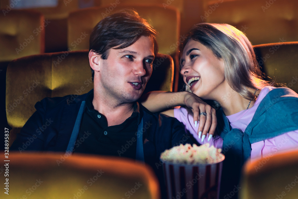 Caucasian lover enjoying to watch movie and eating popcorn together in the cinema