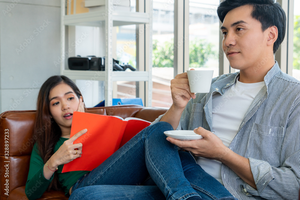 Happy Asian couple drink coffee at home. Love relationship and lifestyle concept.