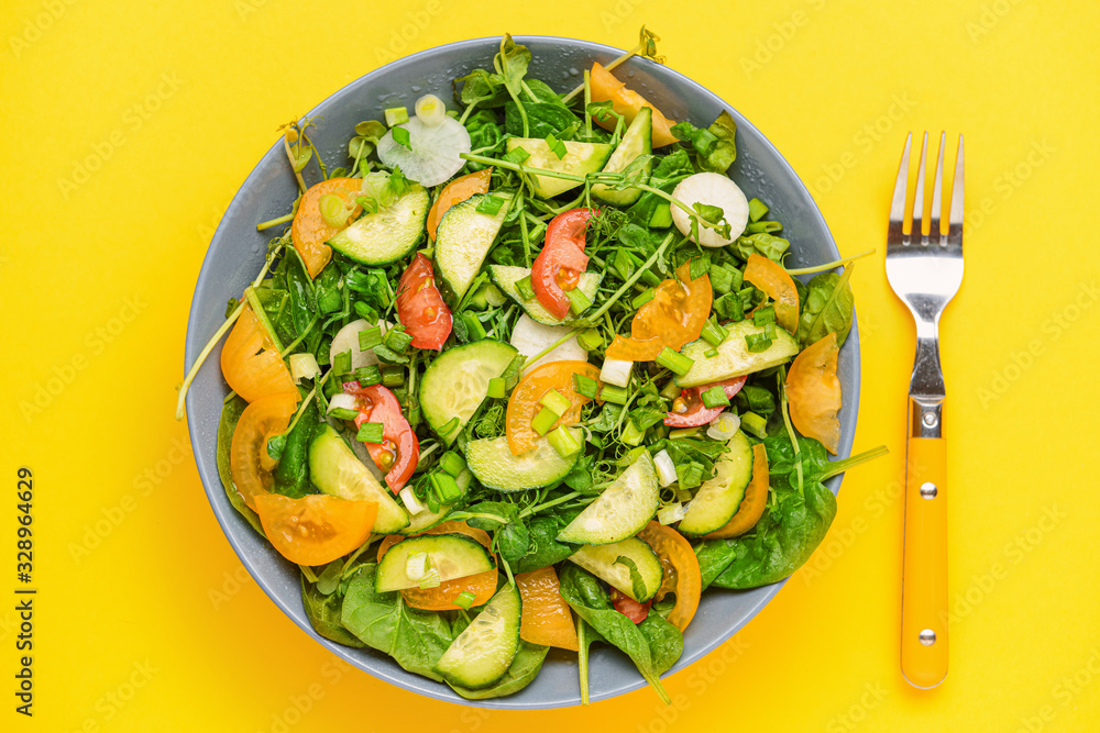 Bowl with tasty salad on color background