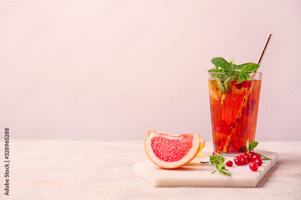 Glass of cold tea on light background