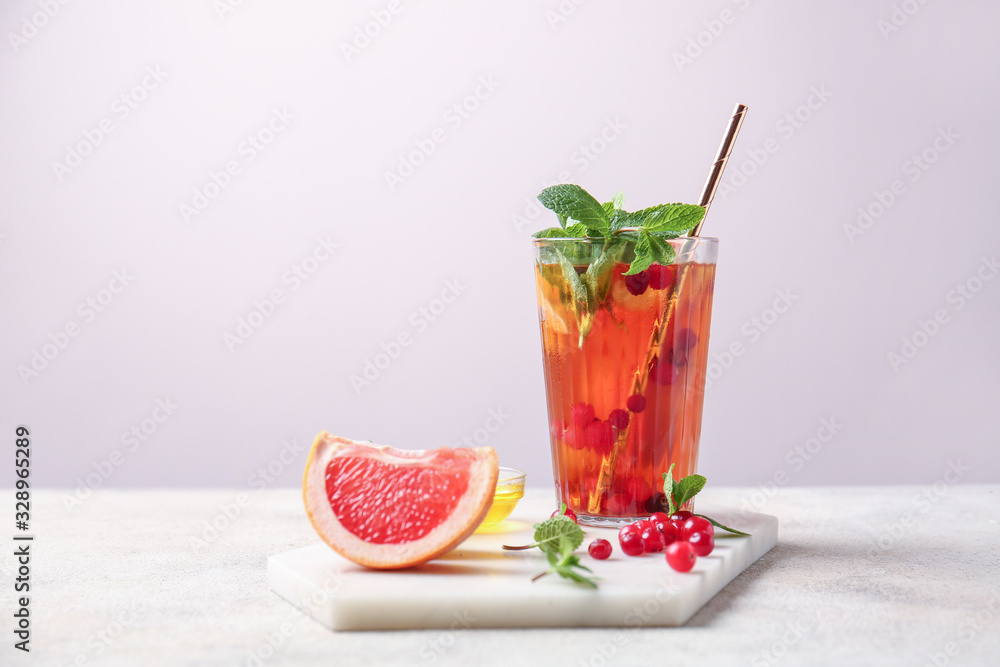 Glass of cold tea on light background