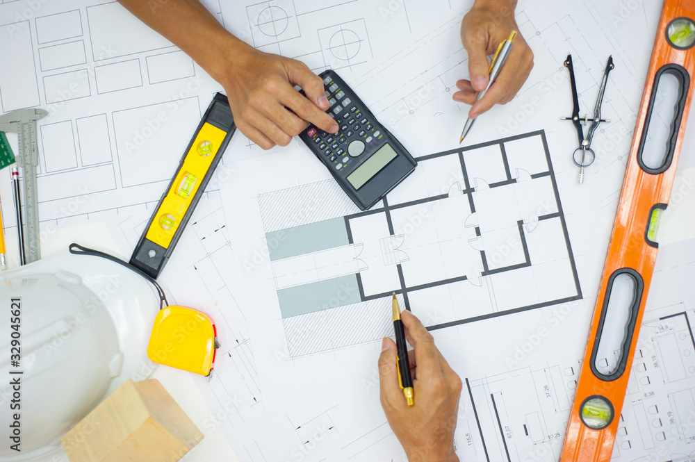 Architects and engineers calculate the structural design of the building on the blueprint.