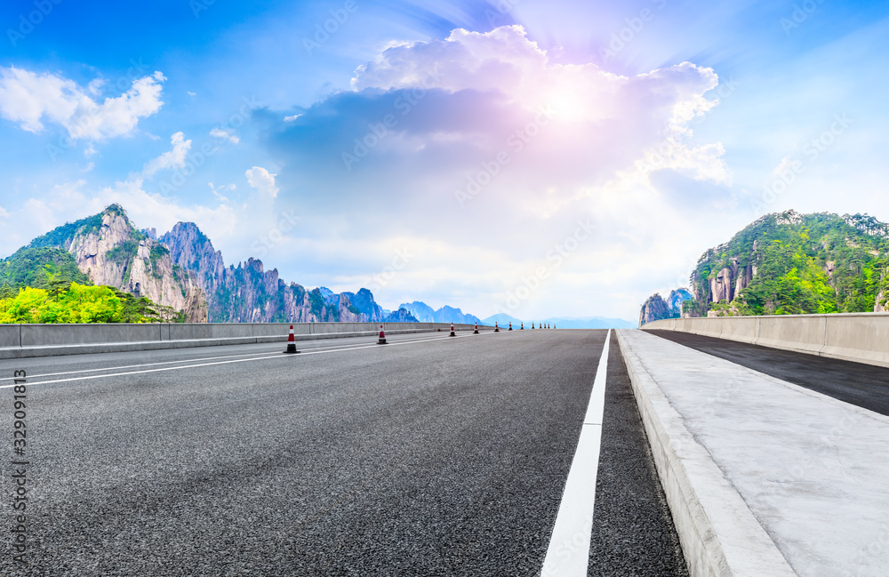 Empty asphalt road and green mountain with beautiful clouds,panoramic view.