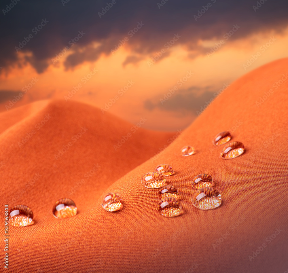 Waterproof fabric with water drops close up against the backdrop of cloudy sunrise