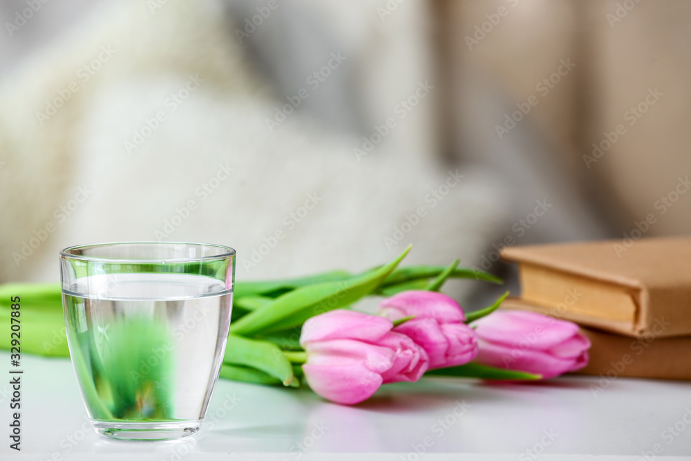 Glass of fresh cold water on table in room