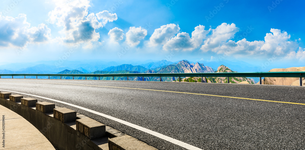 Empty asphalt road and green mountain with beautiful clouds,panoramic view.