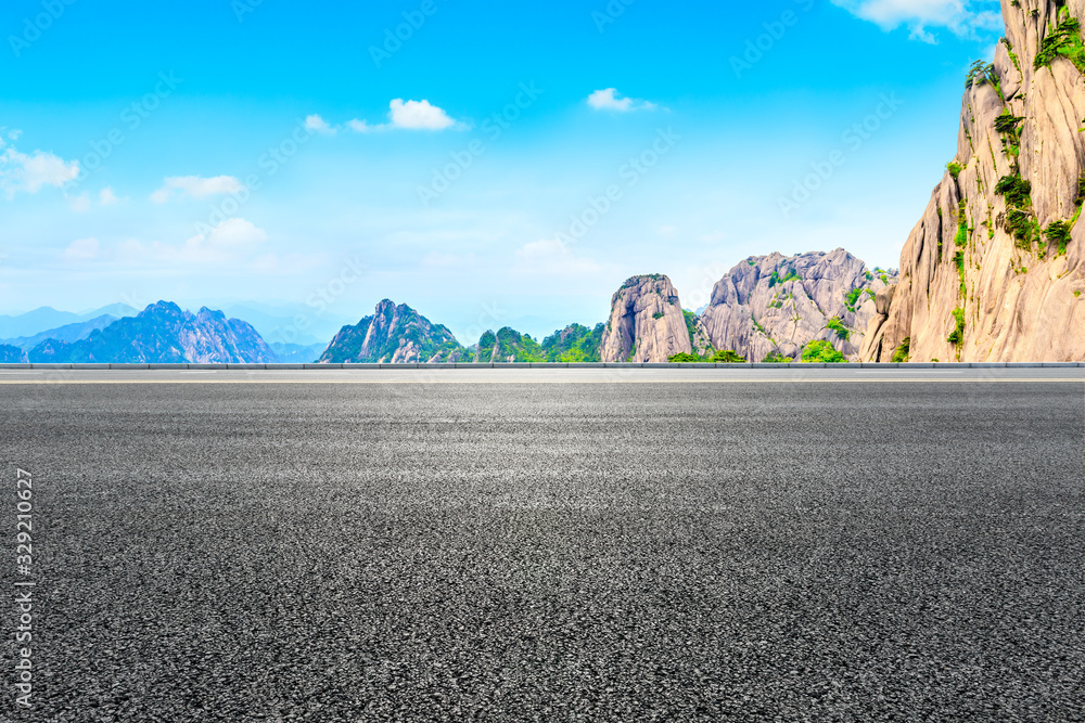 空旷的柏油路，青山白云。