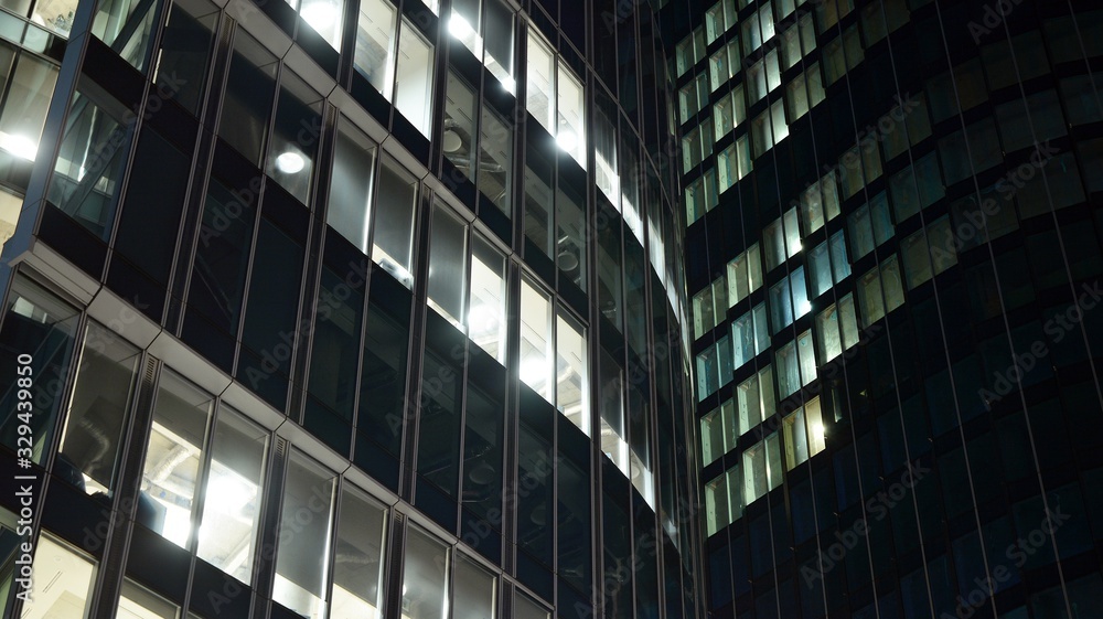 Pattern of office buildings windows illuminated at night. Lighting with Glass architecture facade de